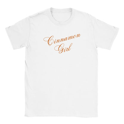 flat lay image of a classic white t-shirt with the slogan 'cinnamon girl' in handwriting style cursive script. the slogan is slanted at a 15 degree angle and the lana del rey lyric slogan is depicted in the color orange in a shade the style of the spice cinnamon